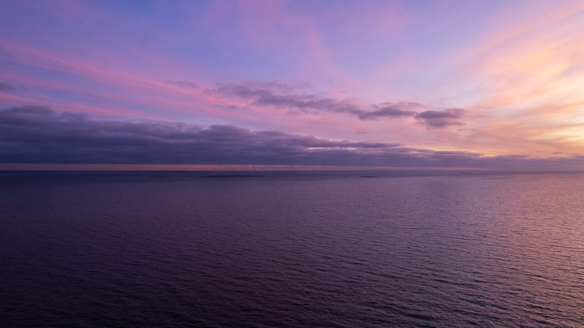 a sunset over a body of water with clouds in the sky