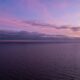 a sunset over a body of water with clouds in the sky