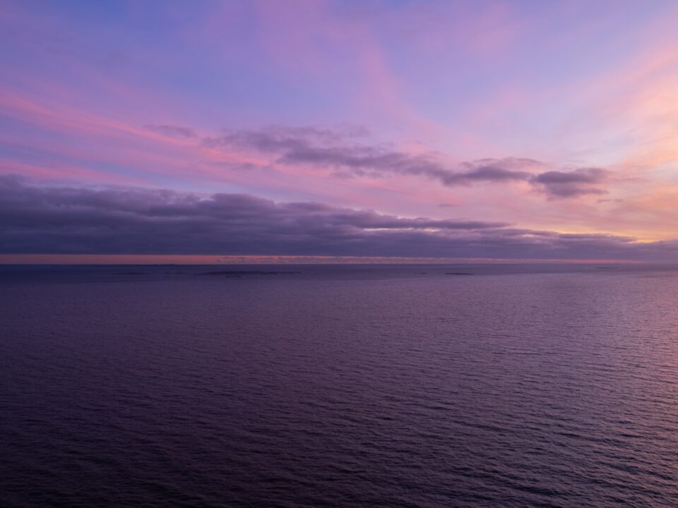 a sunset over a body of water with clouds in the sky