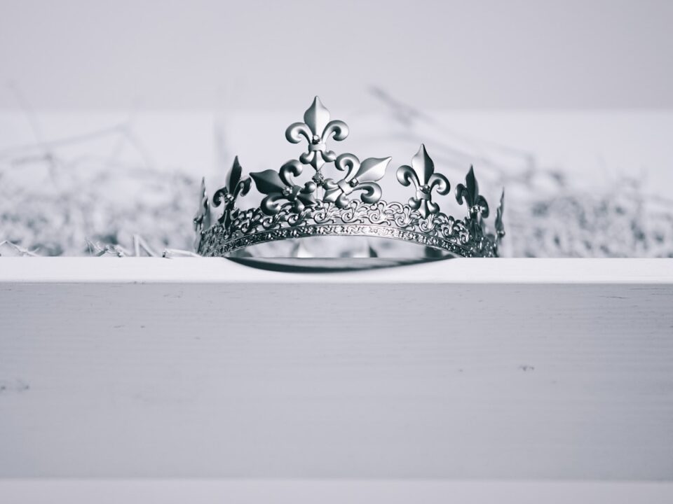 silver-colored crown on top of white wood