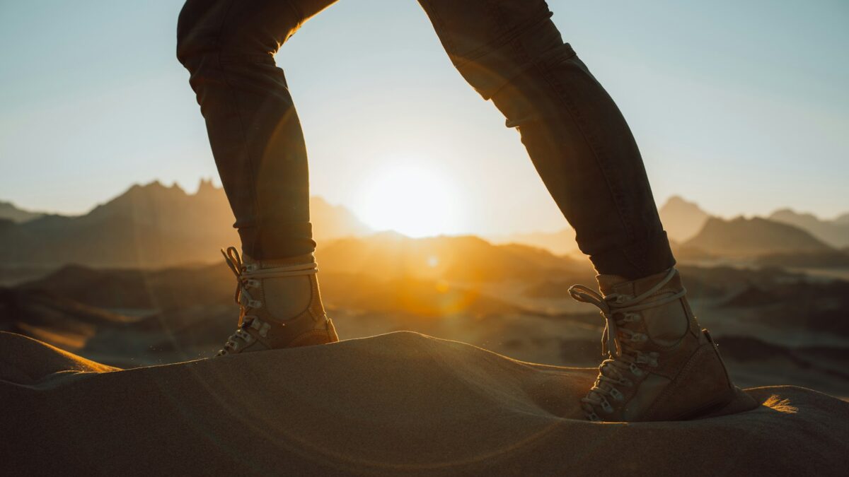 a person standing on top of a sand dune