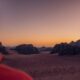 a man in a red shirt is looking at the desert