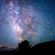 silhouette of trees and mountain under blue sky at nighttime