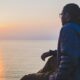 man sitting near body of water