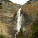 A waterfall is seen from the bottom of a mountain