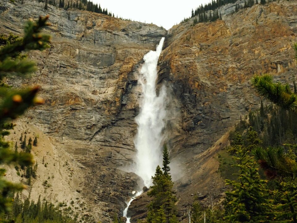 A waterfall is seen from the bottom of a mountain