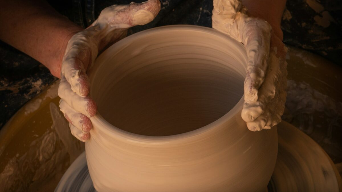 person holding white clay pot