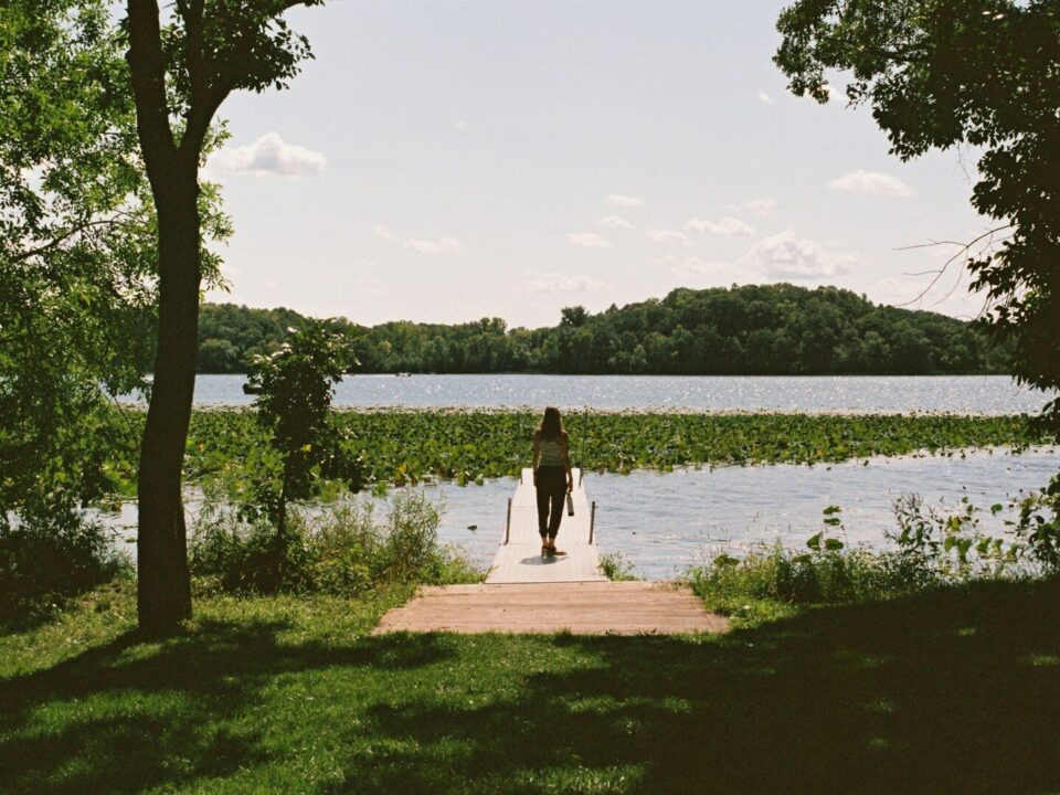 a person standing on a dock near a body of water