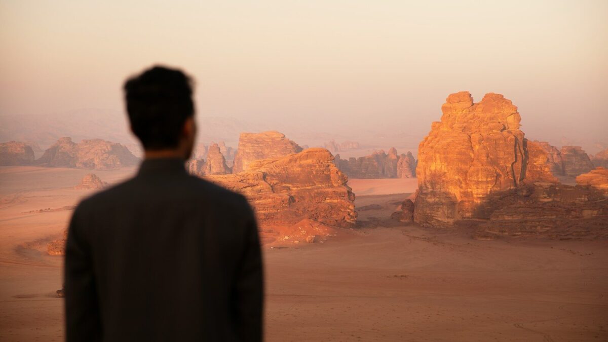 a man standing in front of a desert landscape