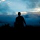 silhouette of person walking towers trees