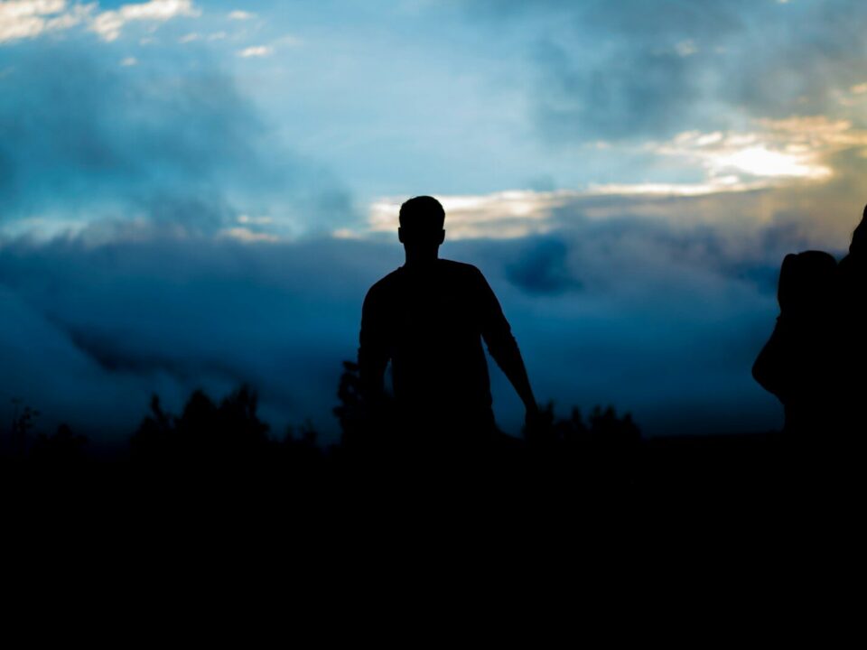 silhouette of person walking towers trees