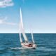 white sail boat on body of wate