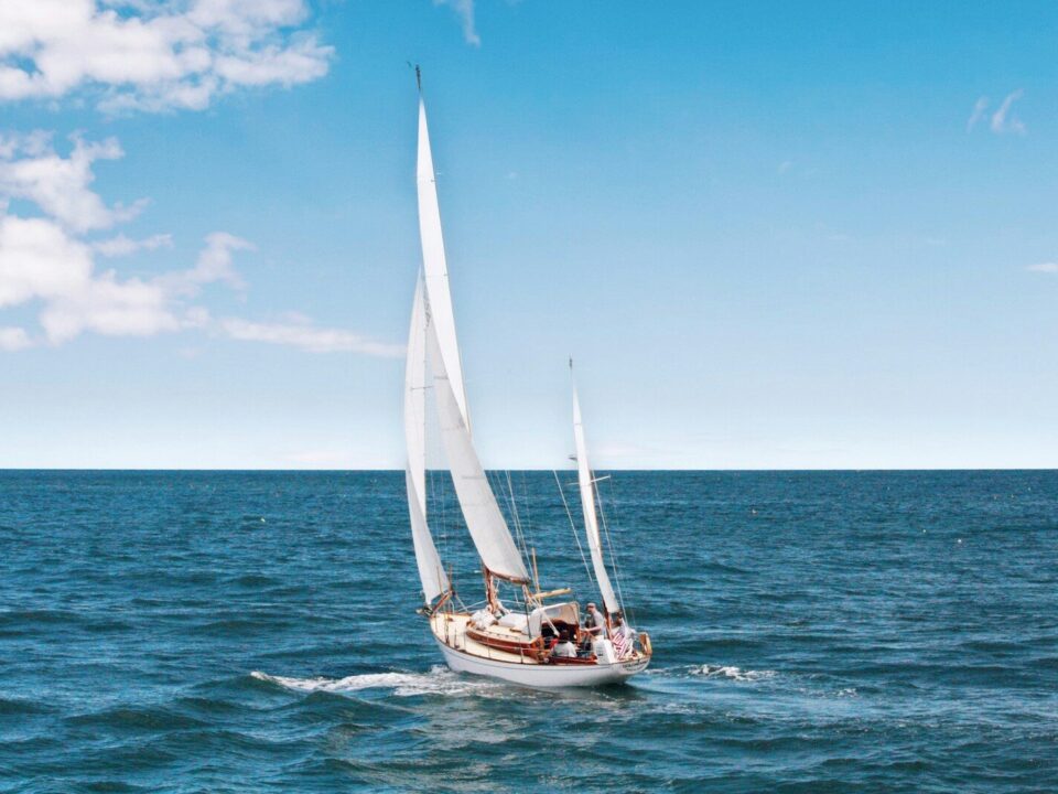 white sail boat on body of wate