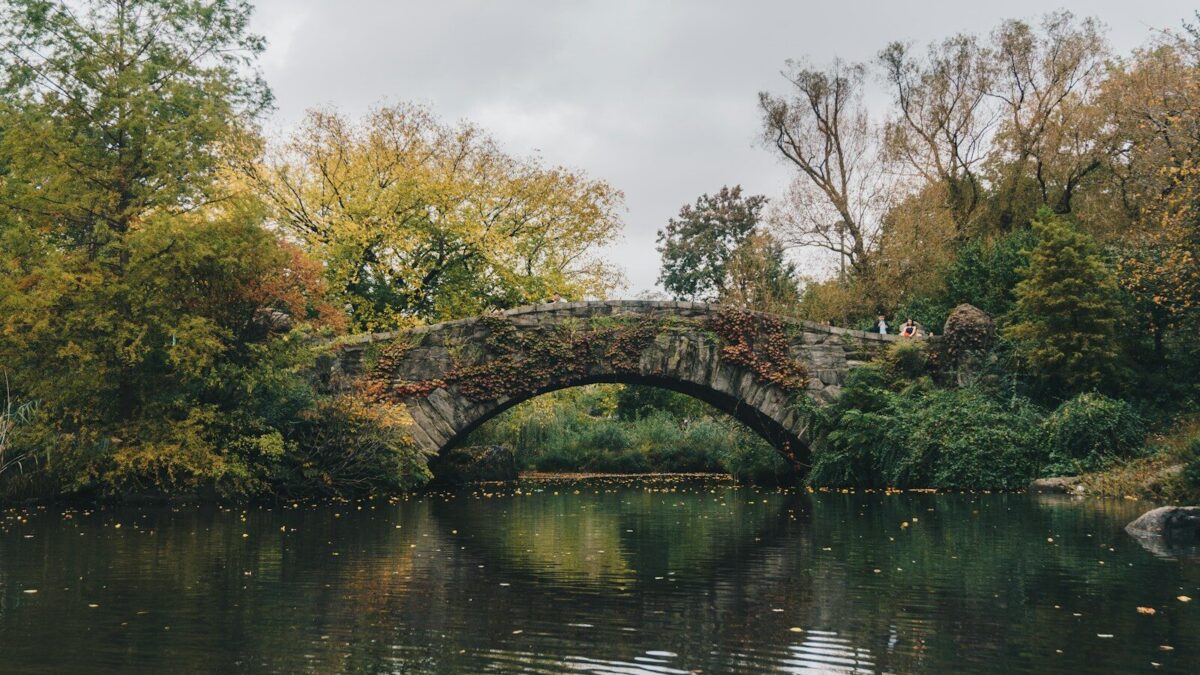 Gapstow Bridge surrounded by autumn trees over a pond in New York City