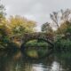 Gapstow Bridge surrounded by autumn trees over a pond in New York City