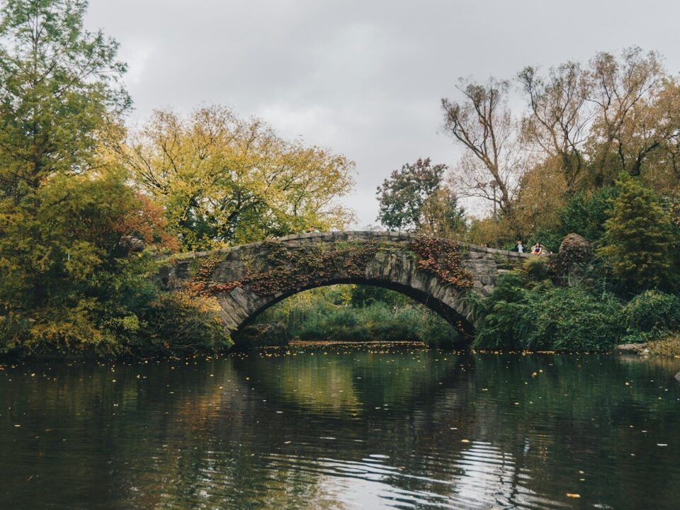 Gapstow Bridge surrounded by autumn trees over a pond in New York City